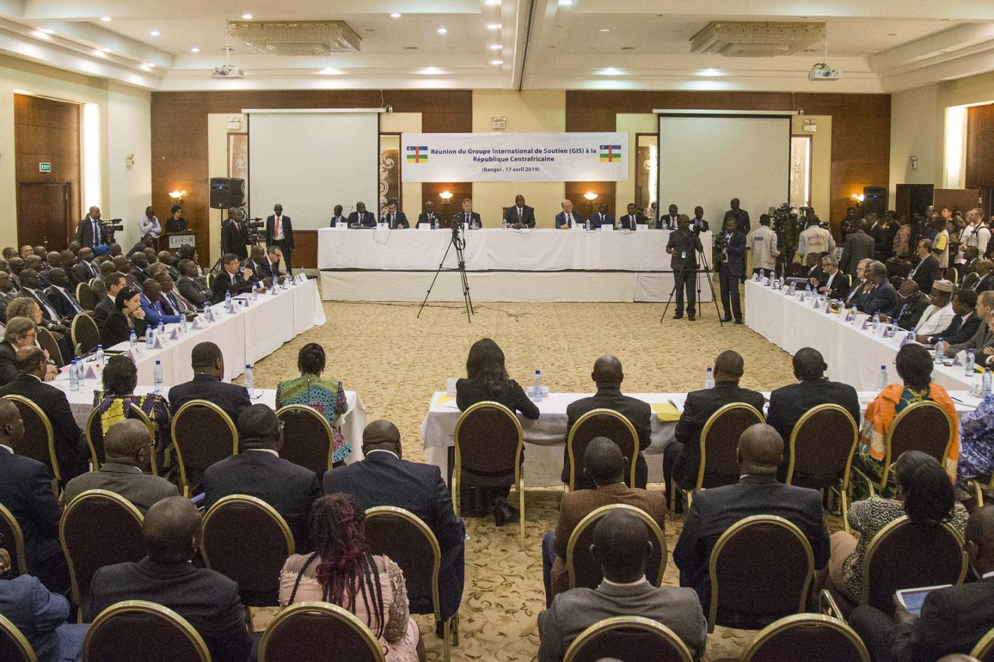 Les participants sont assis dans une salle de conférence.