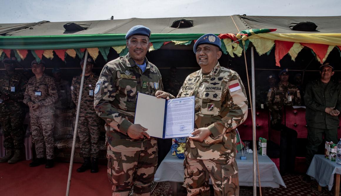 Deux hommes en uniforme militaire brandissent un certificat