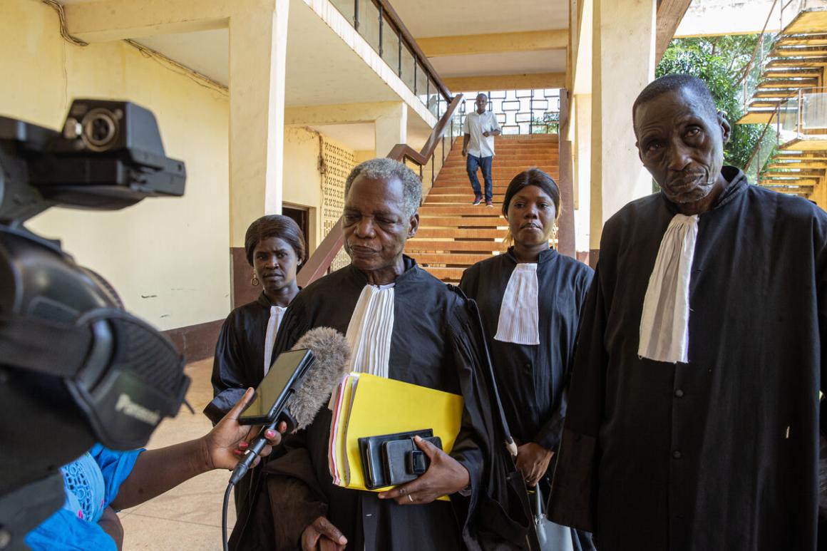 Trois juges s'adressent à une personne tenant un microphone et une caméra vidéo.