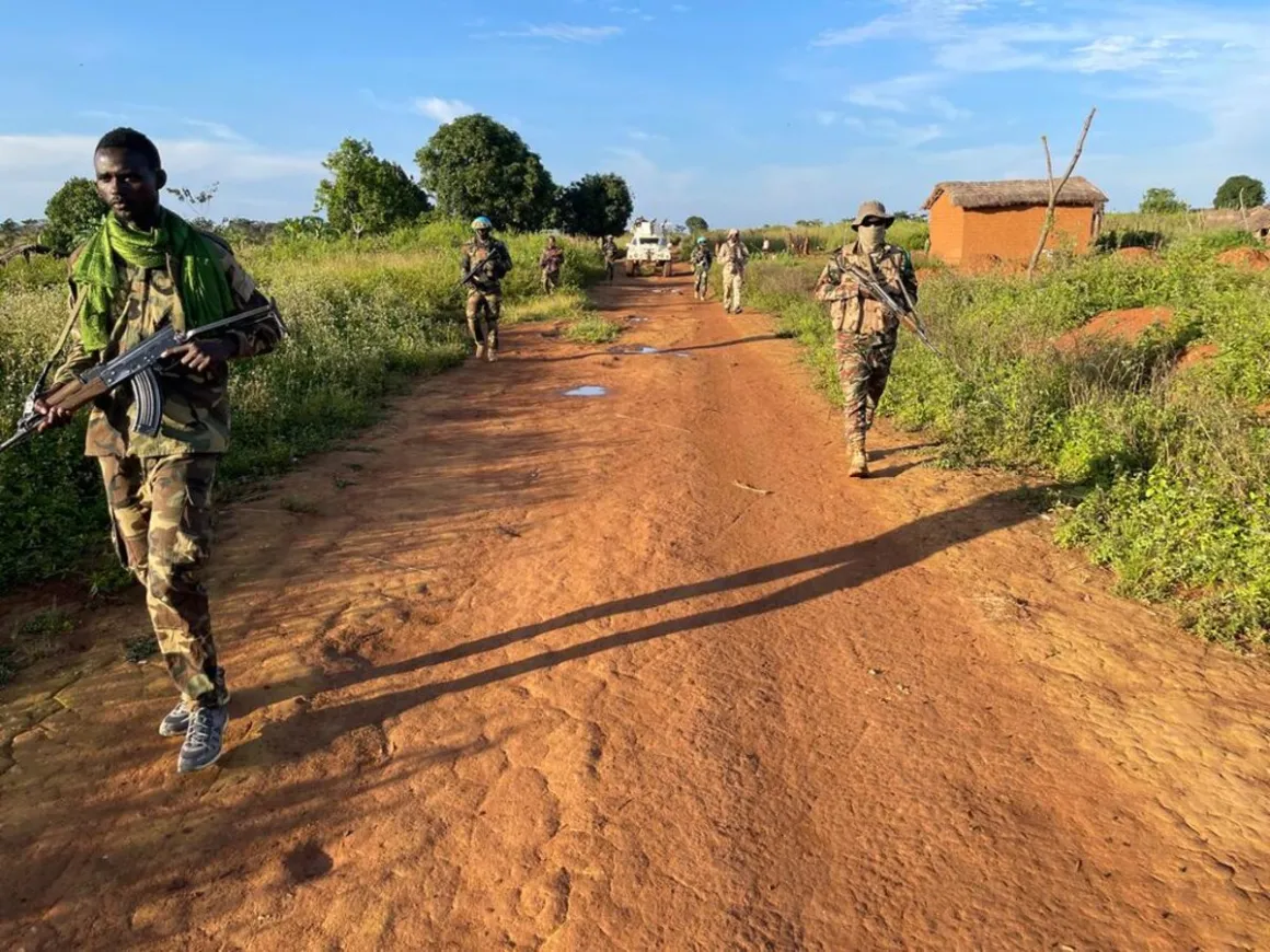 Un groupe d'hommes armés en uniforme militaire descend un chemin de terre