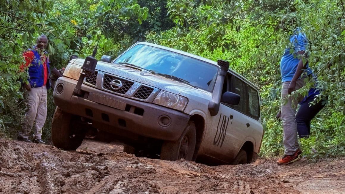 Des soldats de la paix se tiennent à côté de leur véhicule, embourbé.