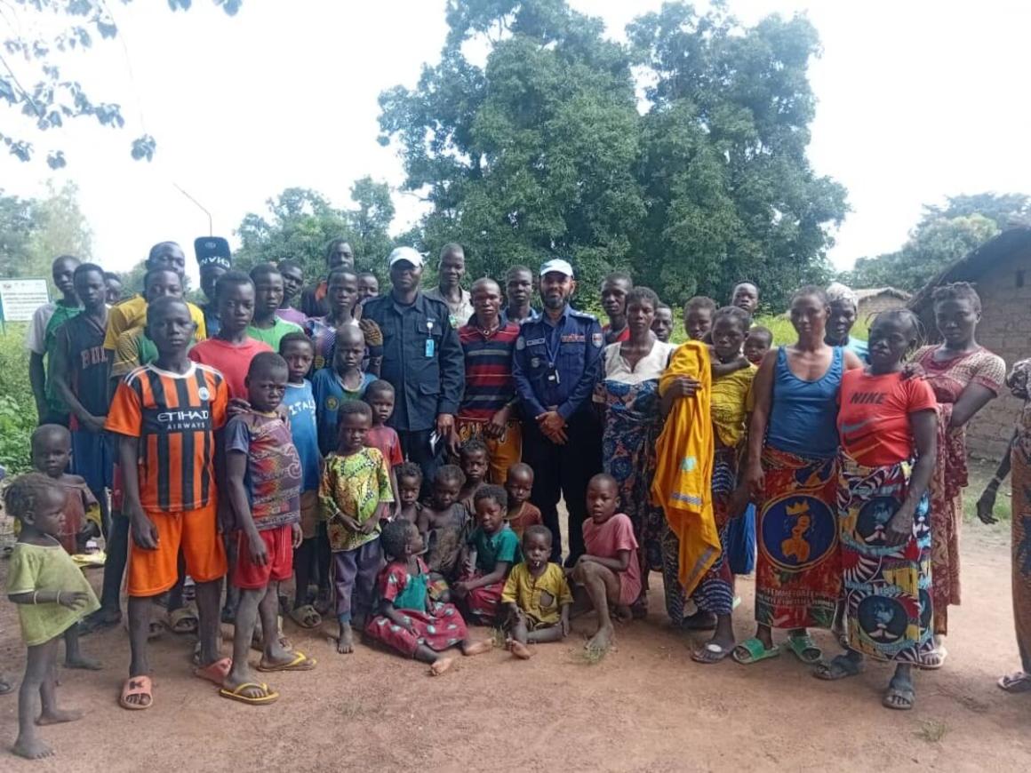 Un grand groupe d'hommes, de femmes et d'enfants pose pour une photo en extérieur en République centrafricaine