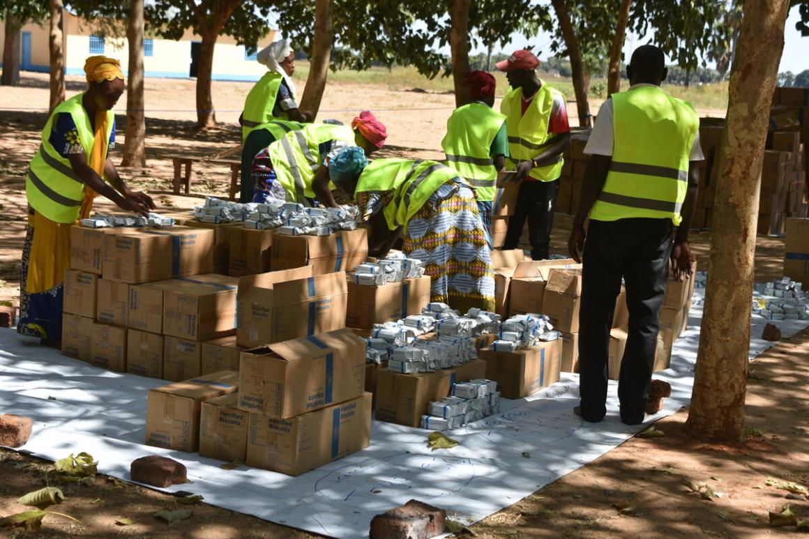 Des personnes en gilets jaunes déchargent des cartons