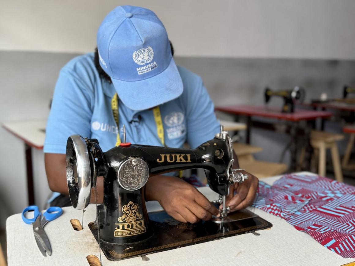une femme est assise à une machine à coudre