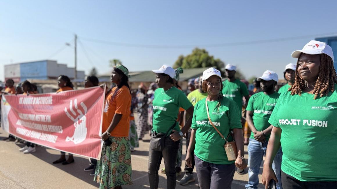 Des gens défilent avec une grande bannière