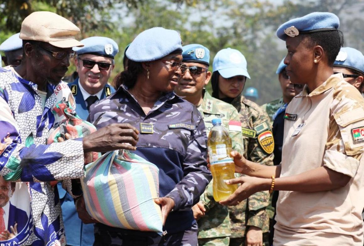 Un groupe de soldats de la paix se tient debout, tenant un sac et une bouteille de liquide.