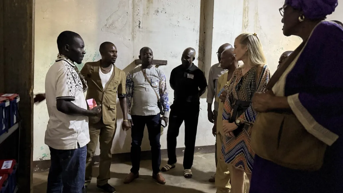 Un groupe d'hommes et de femmes se tient à l'extérieur