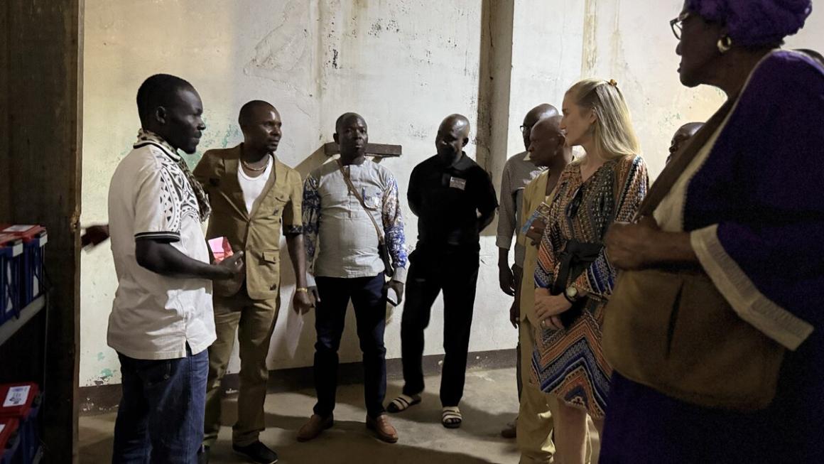 Un groupe d'hommes et de femmes se tient à l'extérieur