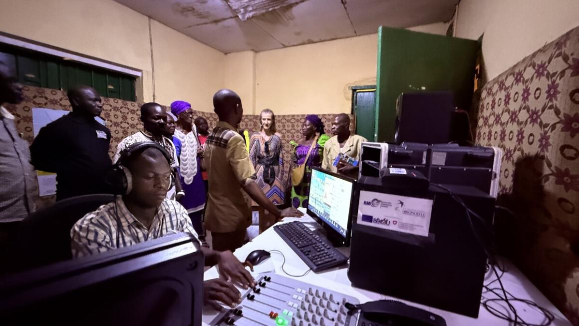 Une pièce remplie de personnes, d'ordinateurs et d'autres équipements