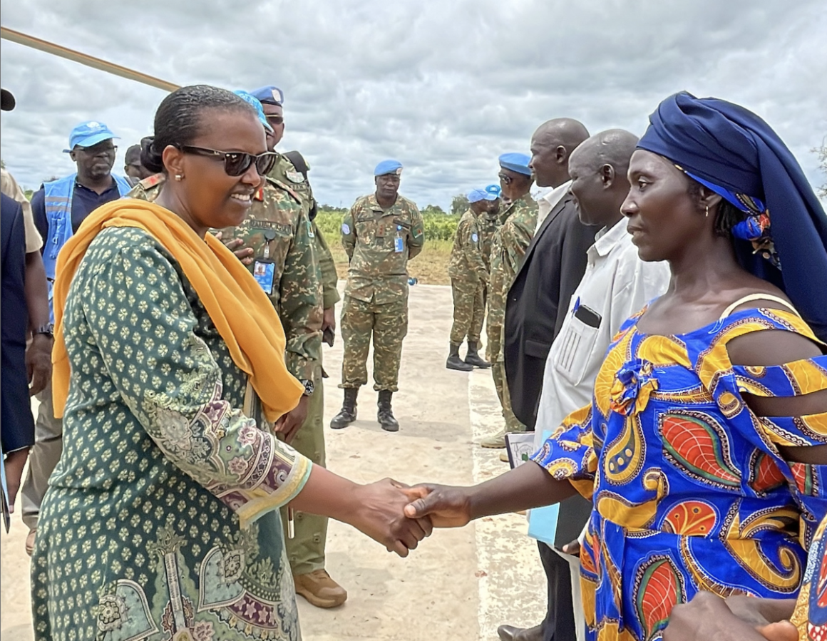 The SRSG shakes hands with a woman
