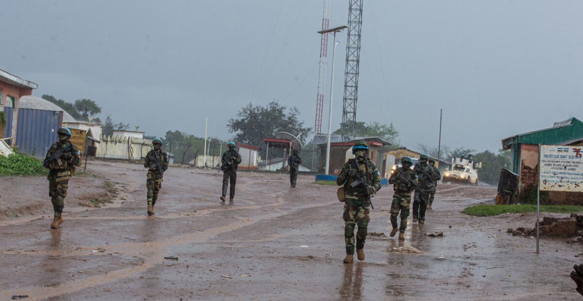 Peacekeepers walk down a path.