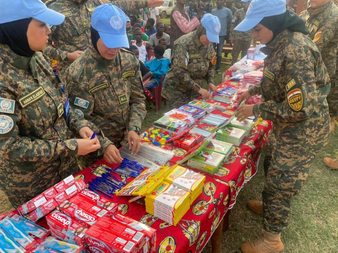 Un groupe de femmes casques bleus disposent des objets sur une table.